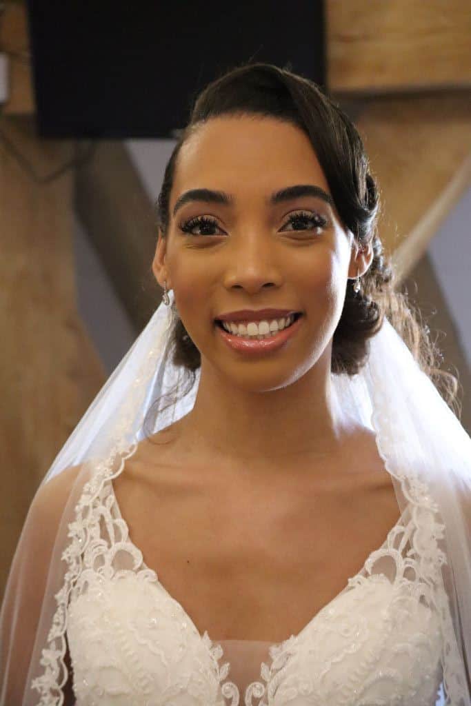 Mixed heritage bride wears a blow-dried bridal updo with her veil. She opted for minimal soft glam makeup to ensure she glows.